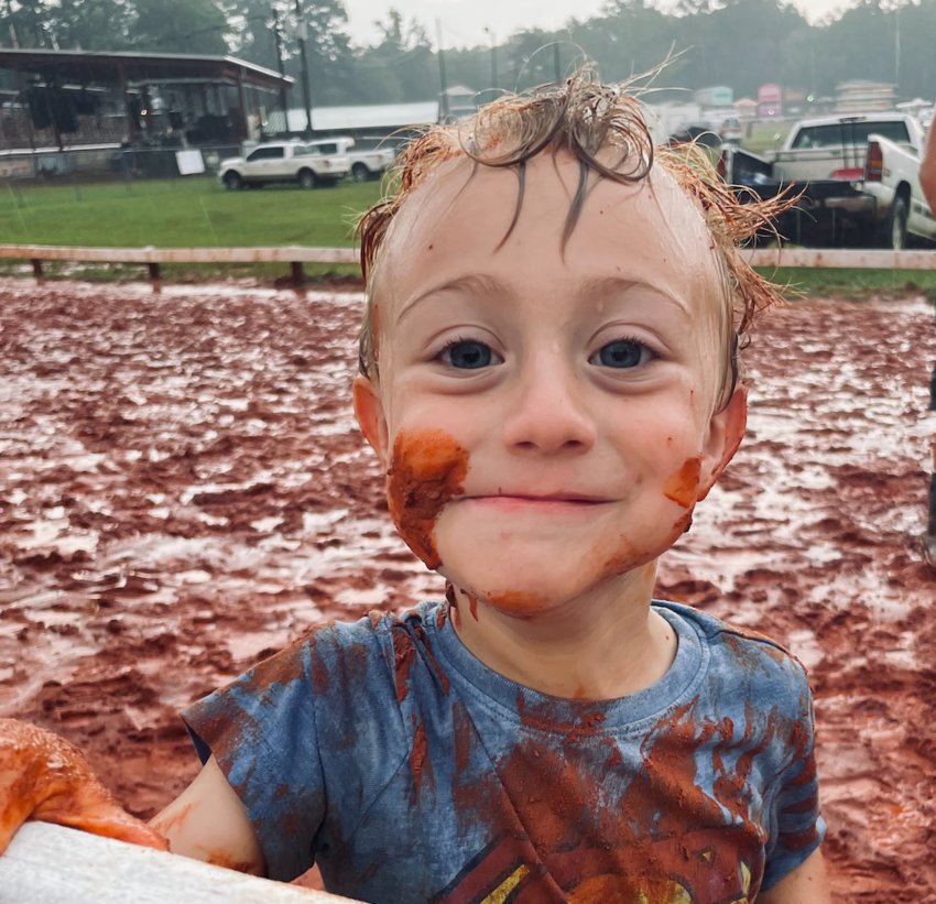 Baylor Weaver, 3, of Cabin 216A decided to take a mudbath on the Racetrack after the races were cancelled on Monday.